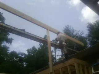 Carpenter setting a ridge beam over a new addition frame — Ice Dam Removal by Roofing Brothers in Drewsey