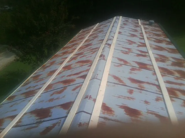 Rusted metal roof panels with new wood purlins before replacement — Storm Damage Roof Repair in Drewsey by Roofing Brothers