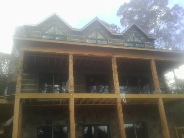 Dormers and porch framing on a large log home under construction — Roof Coating work by our crew in Drewsey
