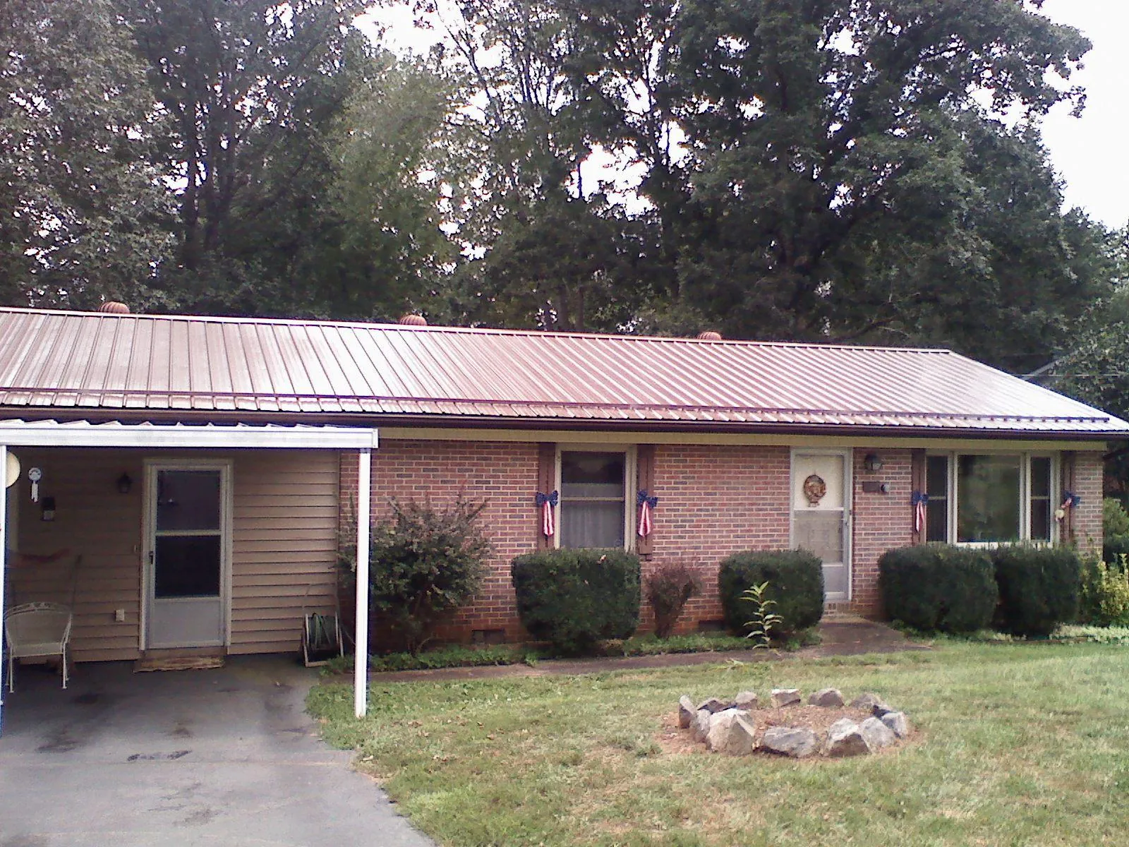 Bronze metal roof and carport on a brick ranch home — Roof Repair work by our crew in Drewsey